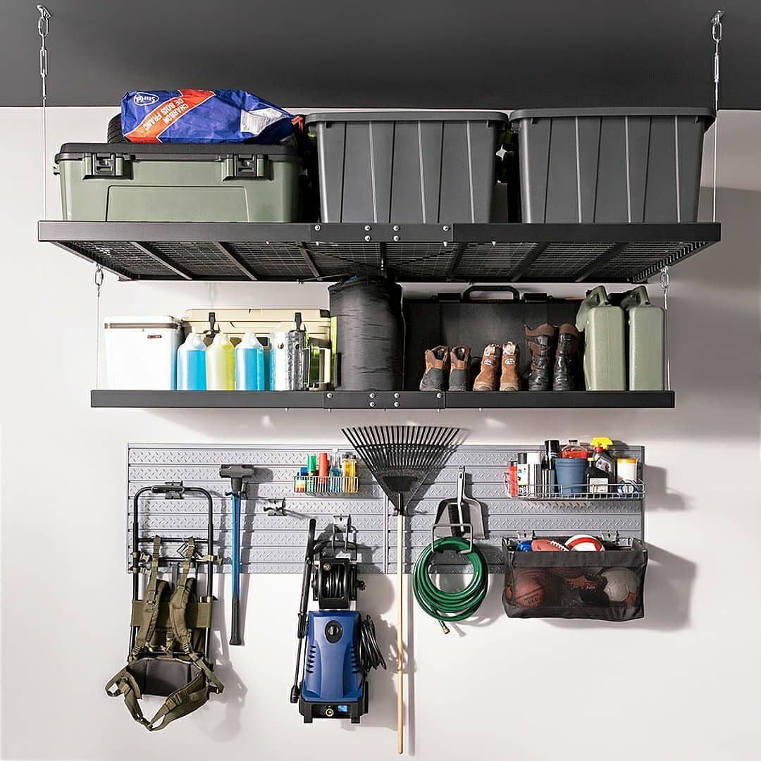 Ceiling suspended black metal shelves and a wall pegboard with various garage tools.