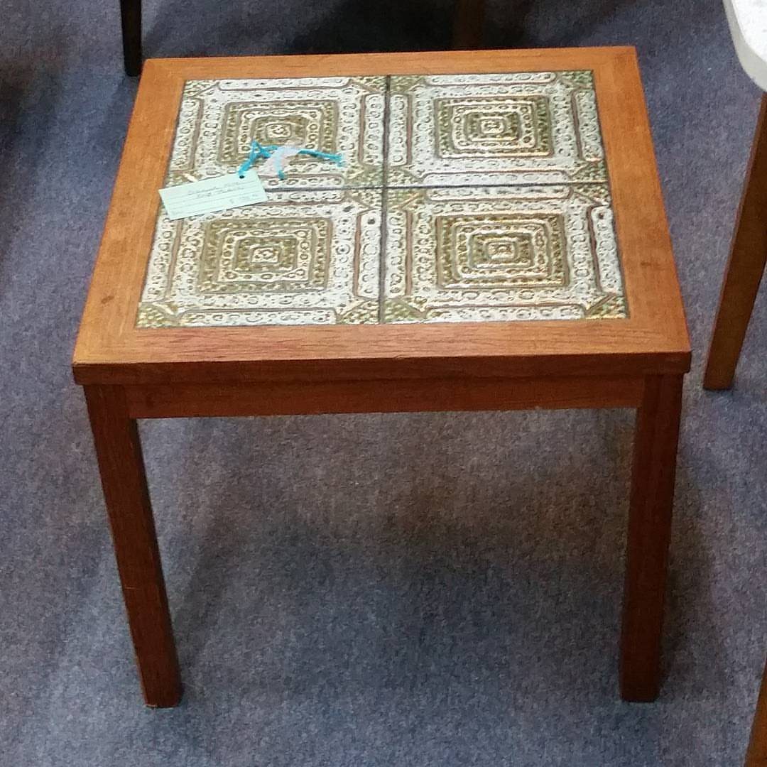 Square wooden end table with decorative patterned tiles inlaid on the top surface.