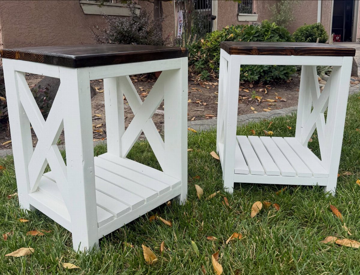 Two white wooden end tables with dark brown tops and X-shaped side supports.