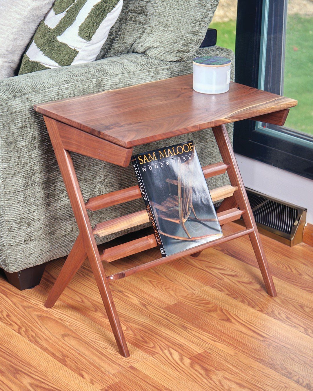 Wooden end table with live edge top and magazine rack next to a sofa