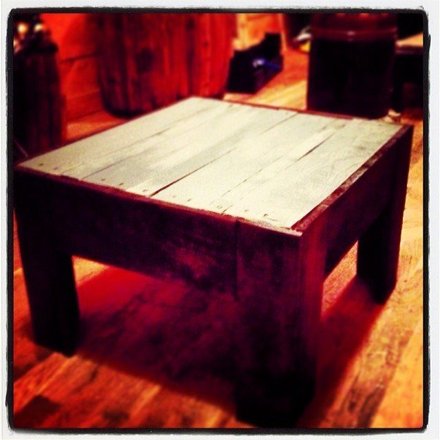 Rustic wooden end table with light plank top and dark brown frame.