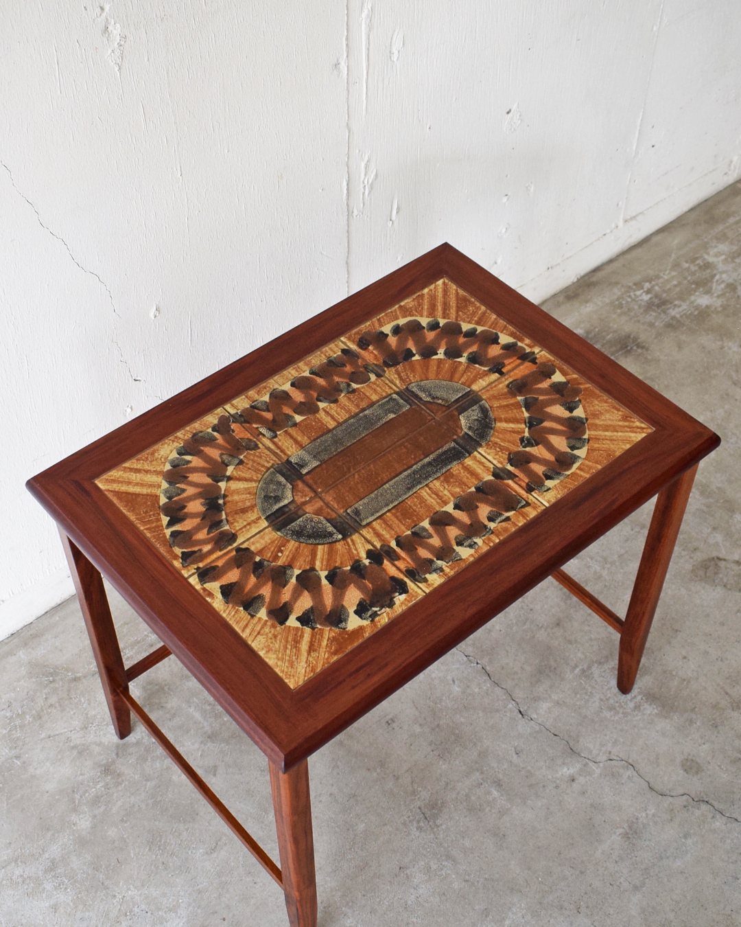 Wooden end table with a detailed oval marquetry inlay on the tabletop.