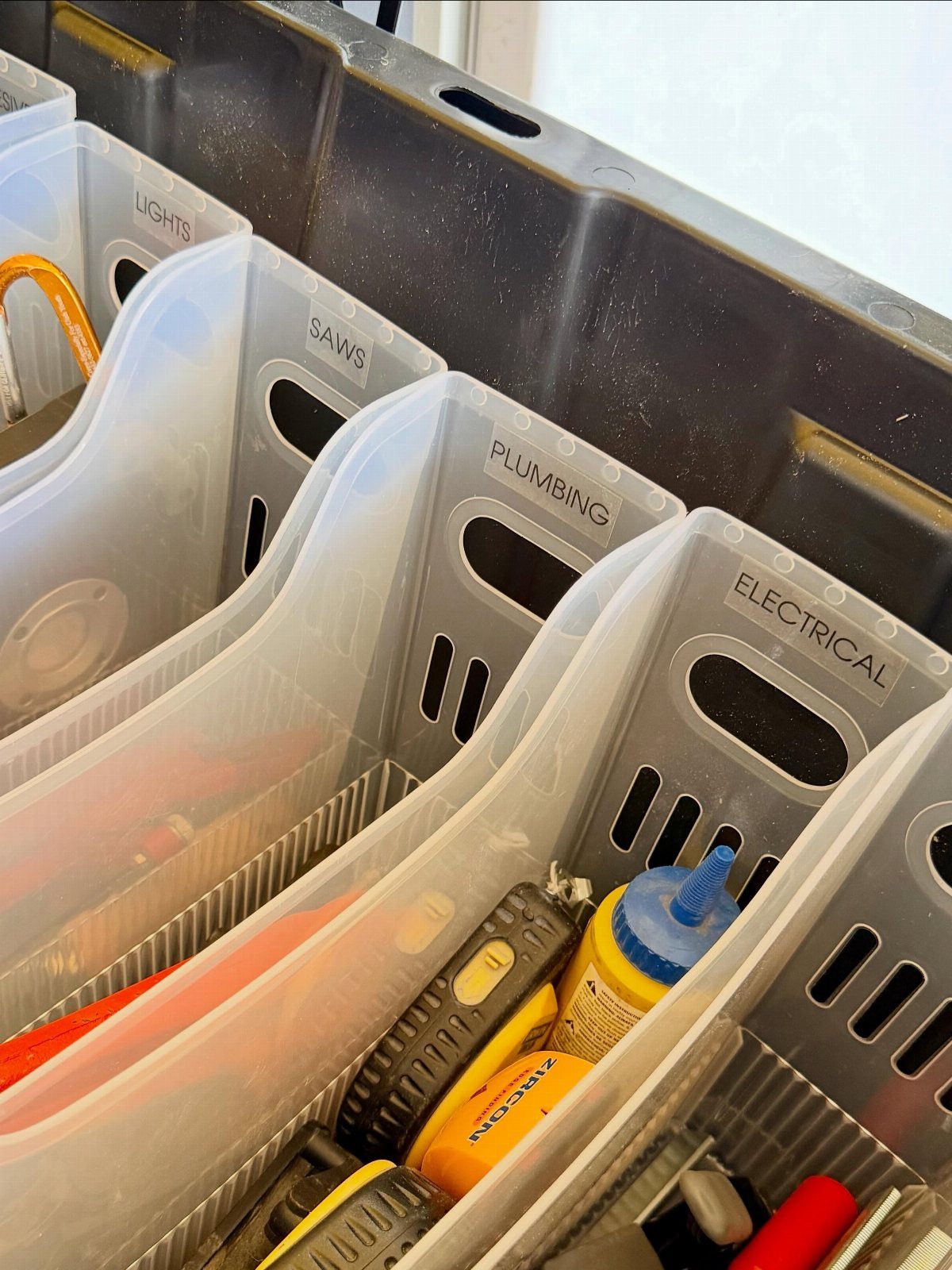 DIY Garage Organization: 17 Ideas to Build and Install 10 Clear plastic labeled storage bins containing tools inside a large black container.