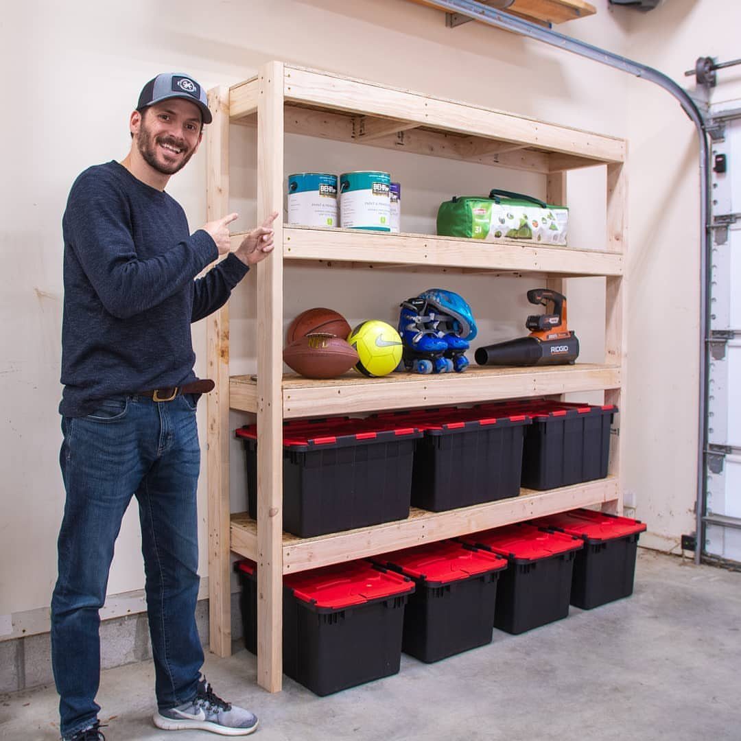 17 Garage Storage Inspiration Ideas to Organize Any Space 2 Man standing next to a large wooden DIY garage shelving unit with storage bins.