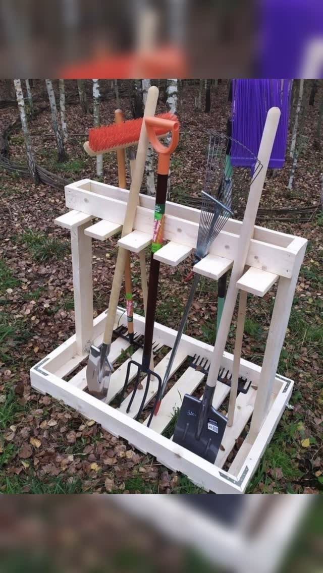 17 Garage Storage Inspiration Ideas to Organize Any Space 7 White wooden garden tool caddy holding rakes and shovels on autumn leaves.