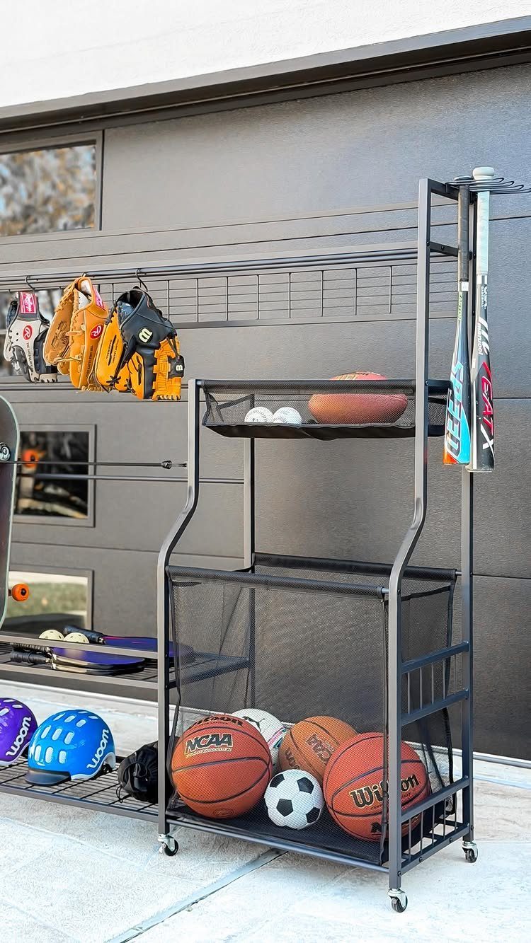 17 Garage Storage Inspiration Ideas to Organize Any Space 16 Black metal rolling sports rack with balls and gloves against a garage door