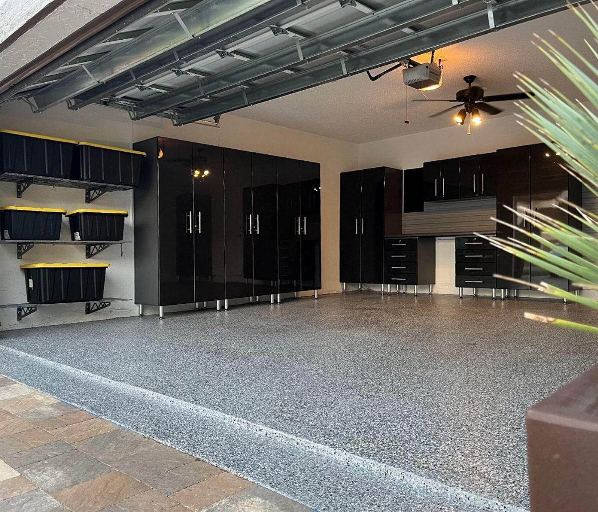 17 Garage Storage Inspiration Ideas to Organize Any Space 6 Glossy black storage cabinets and workbench in a modern garage with epoxy flooring.