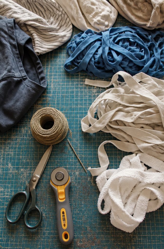 Old T-shirts and cotton sheets arranged with scissors and a tapestry needle