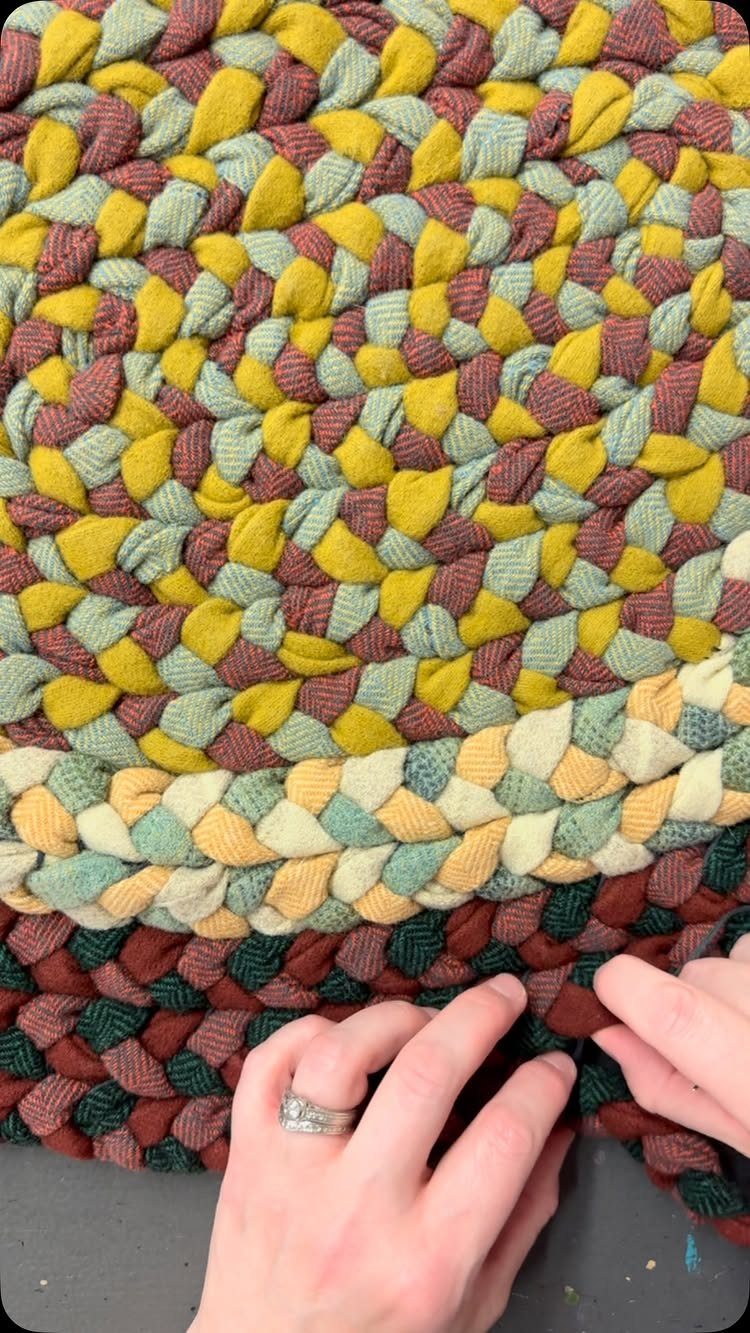 8 Ways to Make a Rag Rug From Braided to Woven 1 Braided rag rug with colorful fabric strips being worked on by hands.