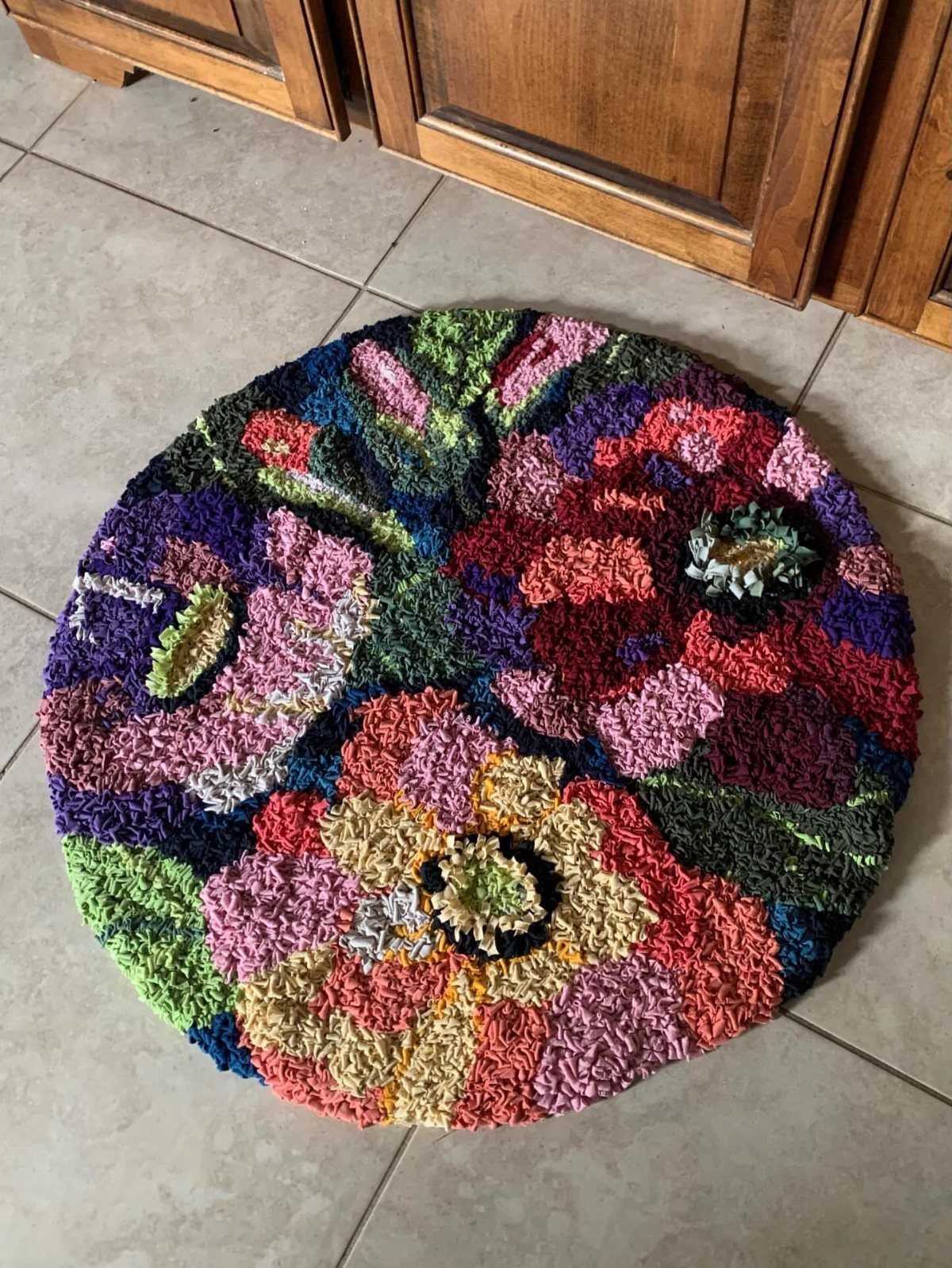8 Ways to Make a Rag Rug From Braided to Woven 8 Circular floral rag rug with vibrant colors on a light tiled floor.