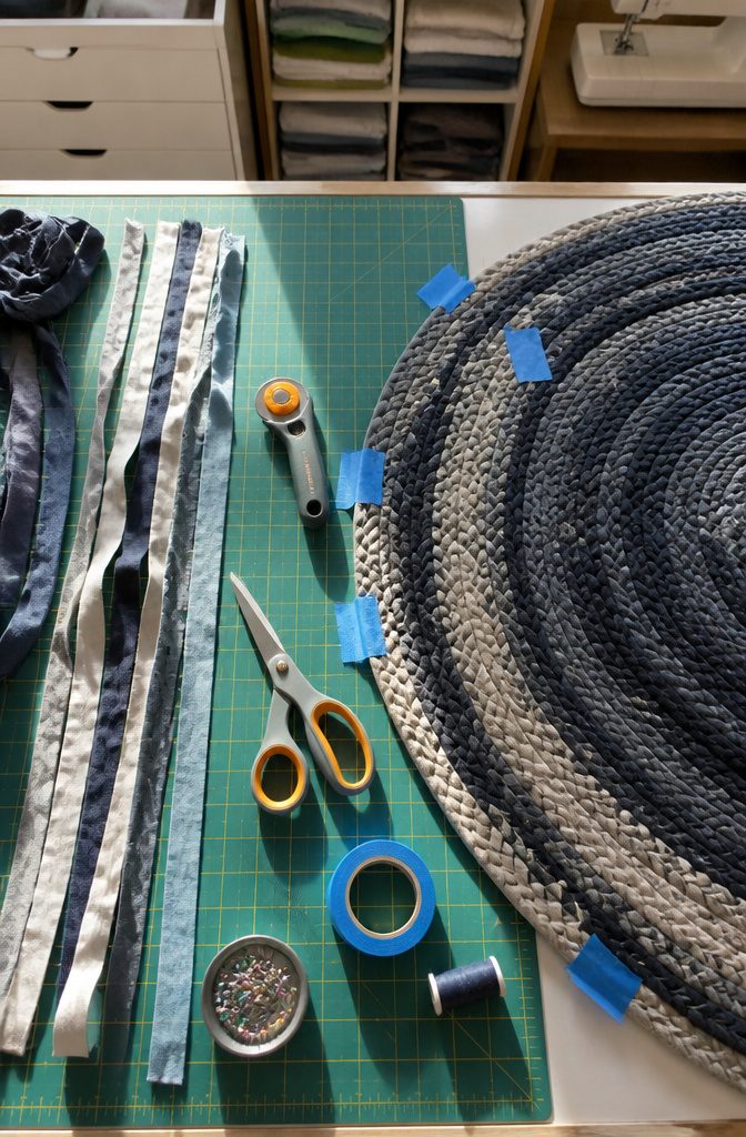 Rotary cutter and sewing tools arranged beside T-shirt fabric strips