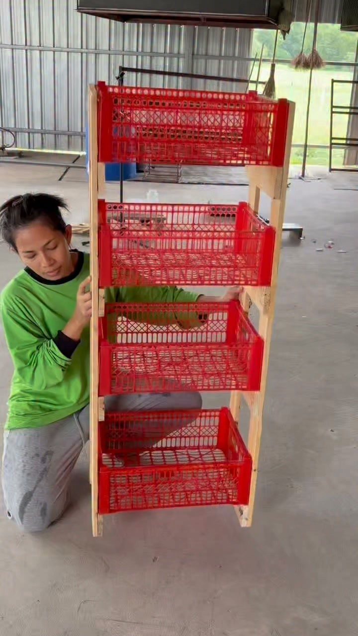 Wooden storage rack holding four red plastic mesh totes in a garage.